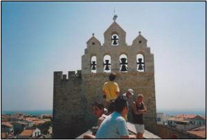 Church bells on the roof dominate the skyline over Saintes-Maries and the sea