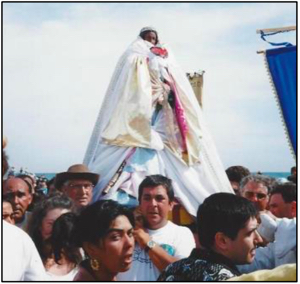 Reliquary of Saint Sara is carried to the sea with a <i>gardian</i> (in hat), some banners and Roma